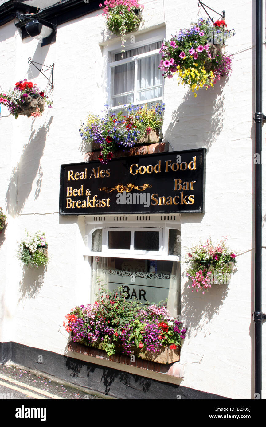 Quaint English pub with many hanging baskets decorating the facade