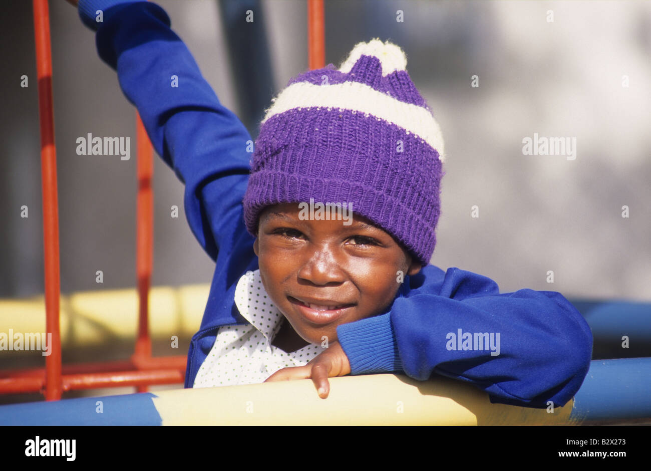 Little African orphan playing on the climbing frame at the orphanage, Zimbabwe Stock Photo