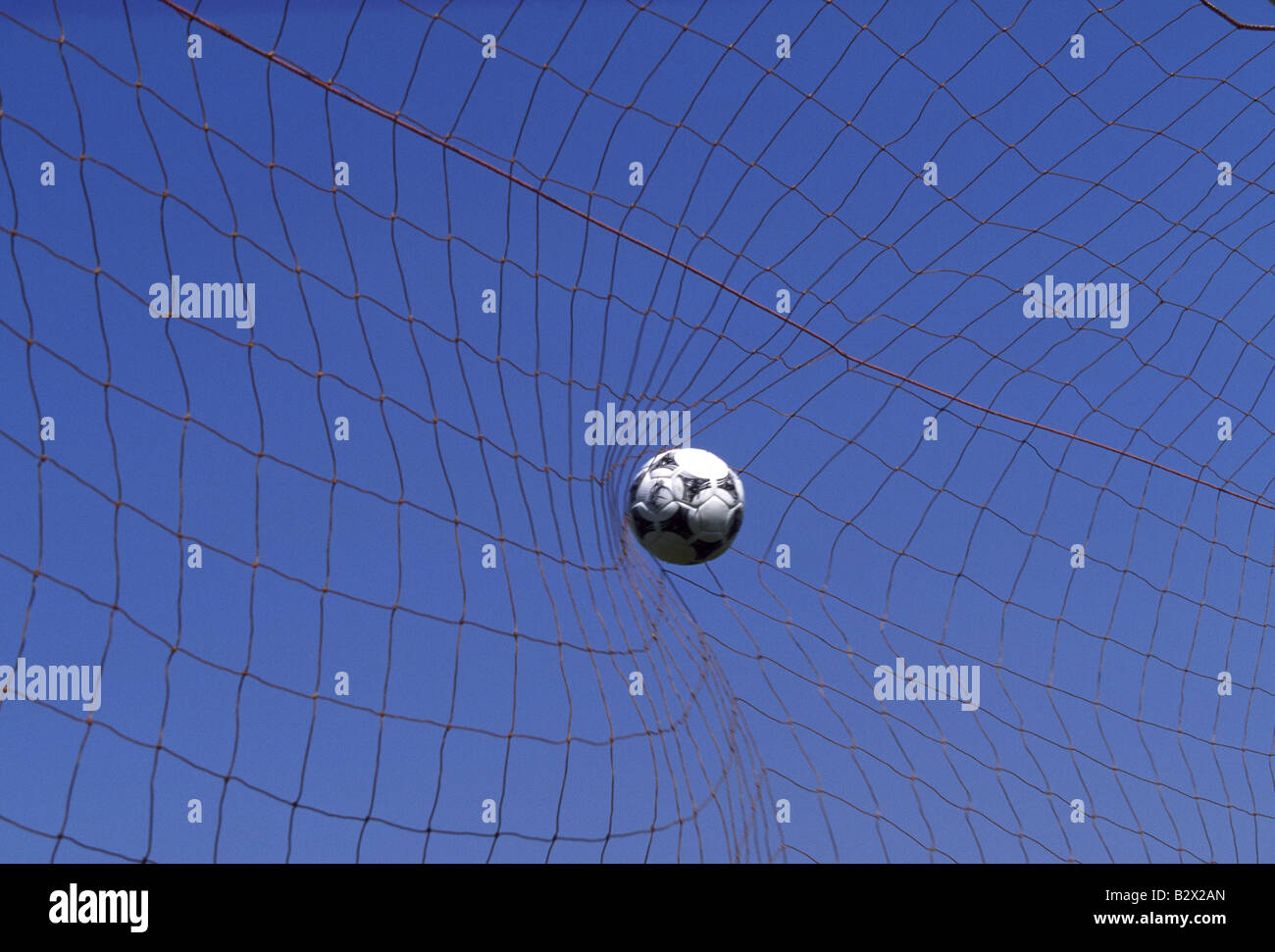 Football hits the back of net against blue sky Stock Photo Alamy
