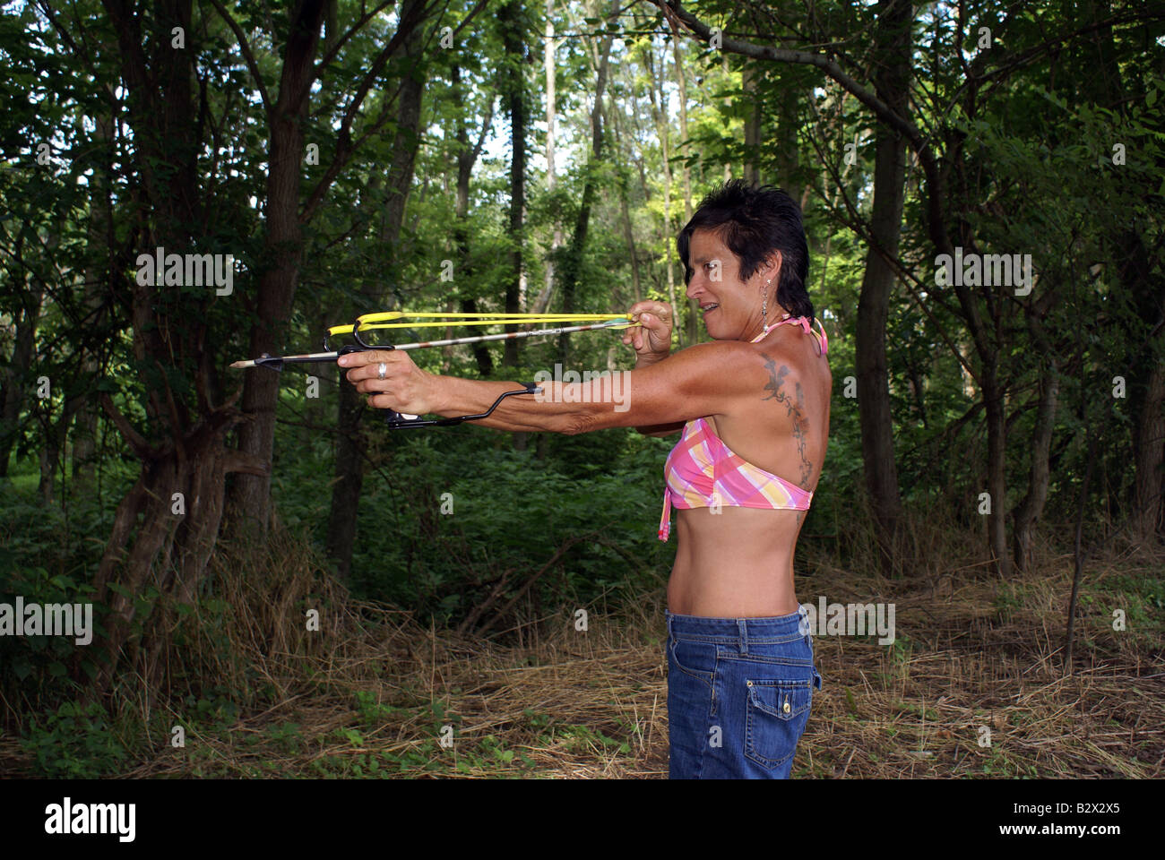 Woman shooting arrow slingshot hi-res stock photography and images