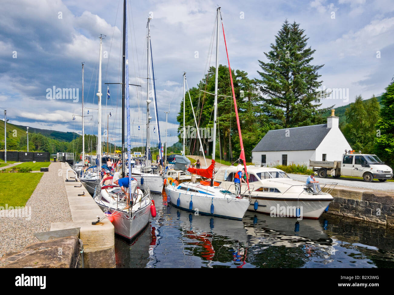 A full lock of Sailing and motor boats moored in the Loch Lochy Laggan locks on the Caledonian Canal in Scotland - gates closing Stock Photo
