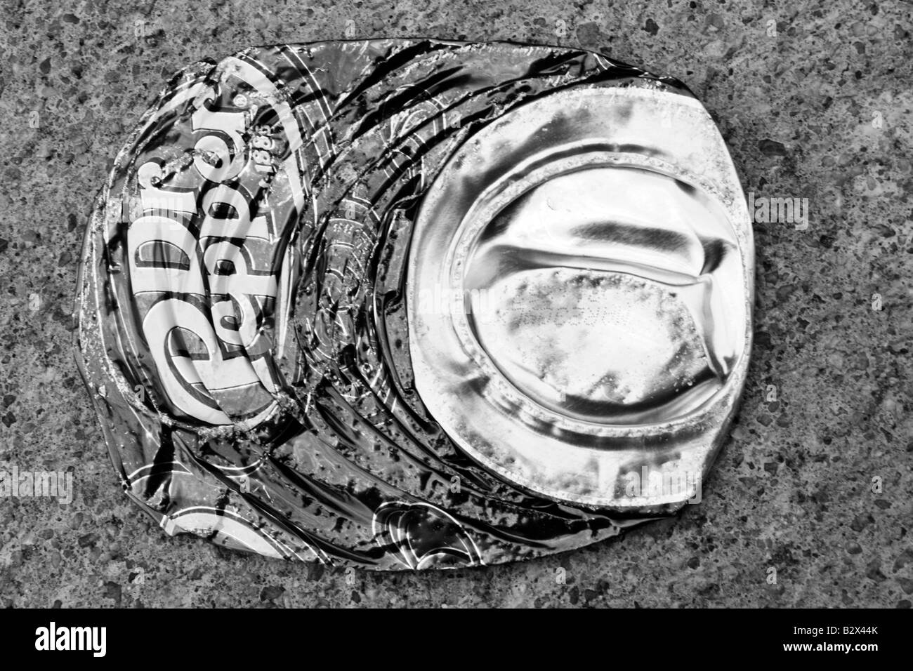 Aluminum soda pop can flattened sideways in concentric rings on concrete. Stock Photo