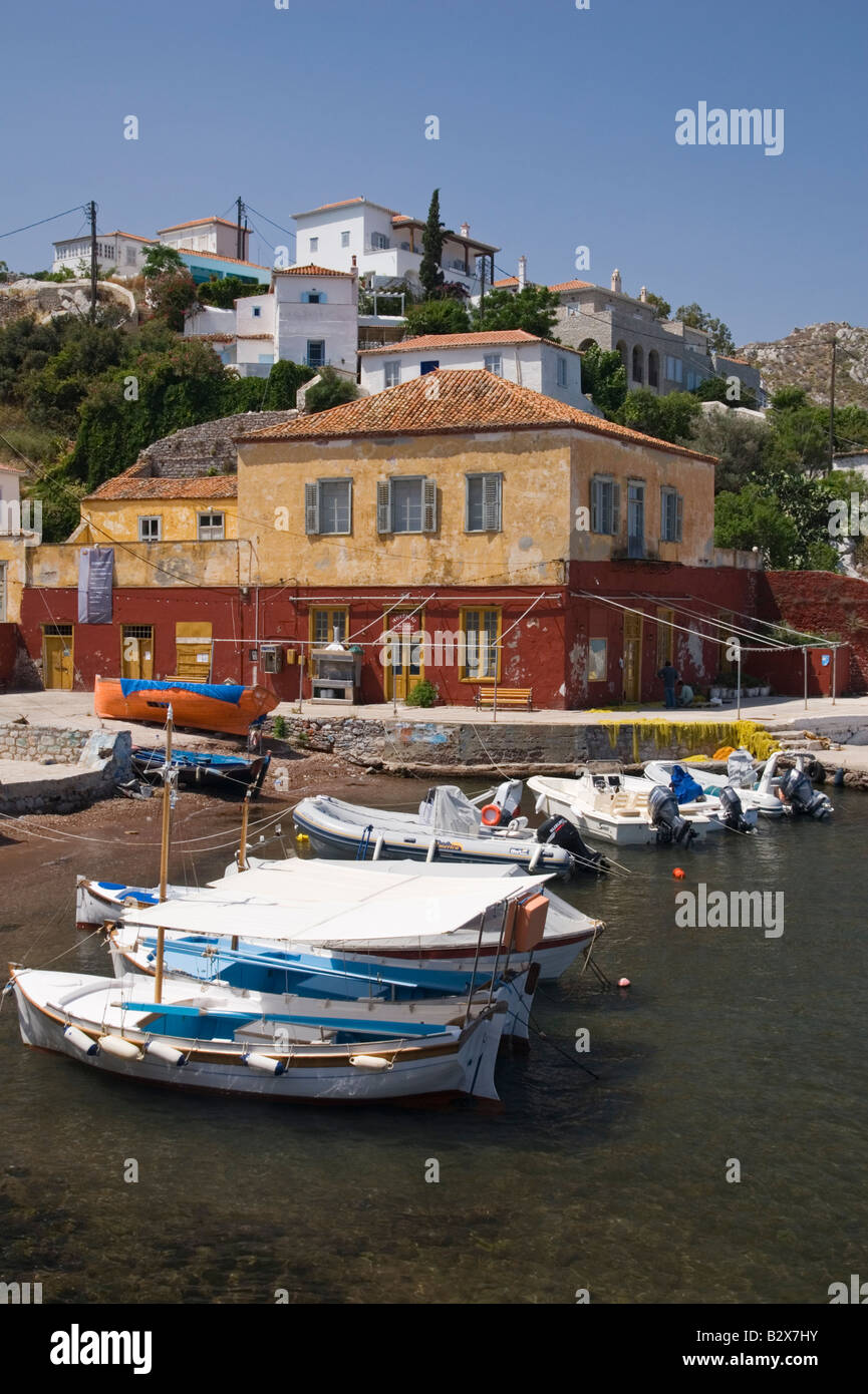 One of the two house covered hills that overlook the small boat filled harbour of Kamini on the island of Hydra, Greece Stock Photo