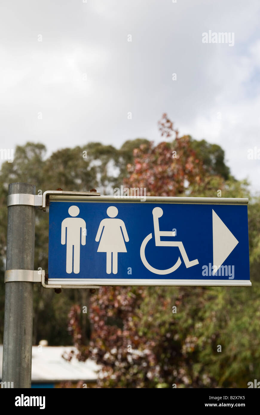 Sign directing people towards the location of public toilets with images of men, women and disabled people Stock Photo