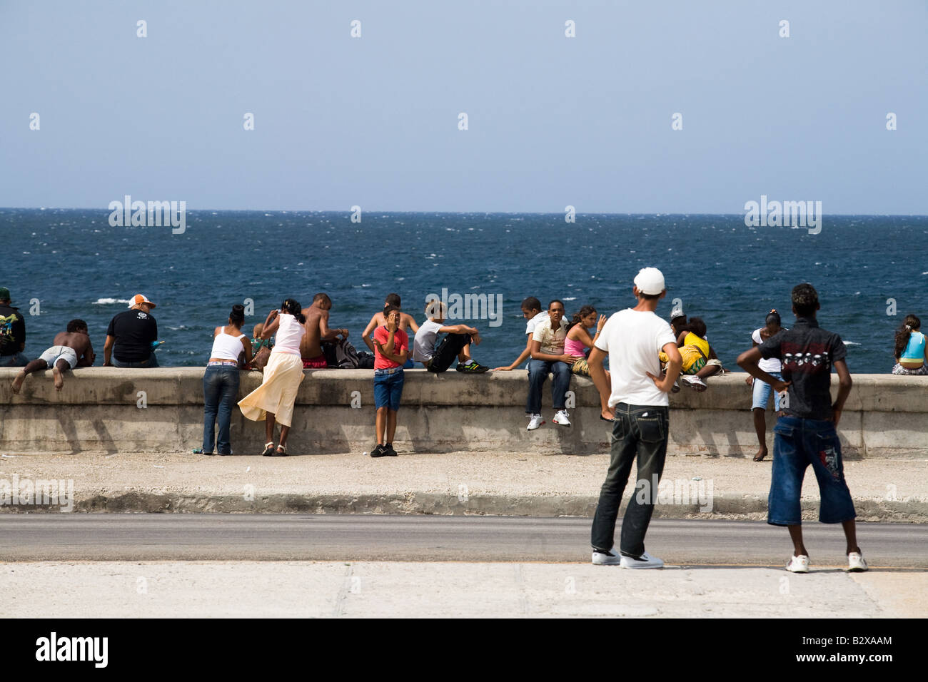 People hang out by the malecon in Havana, Cuba Stock Photo