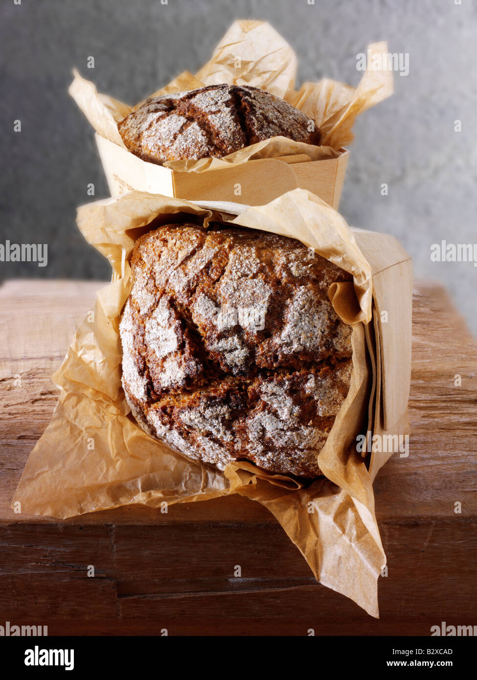 loaves of Artisan Rye bread in a rustic setting on a wood table Stock Photo