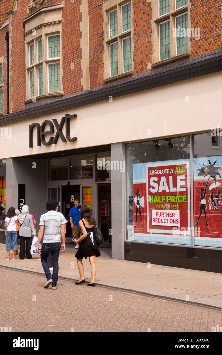 The Next sale with shoppers walking by in the uk Stock Photo Alamy