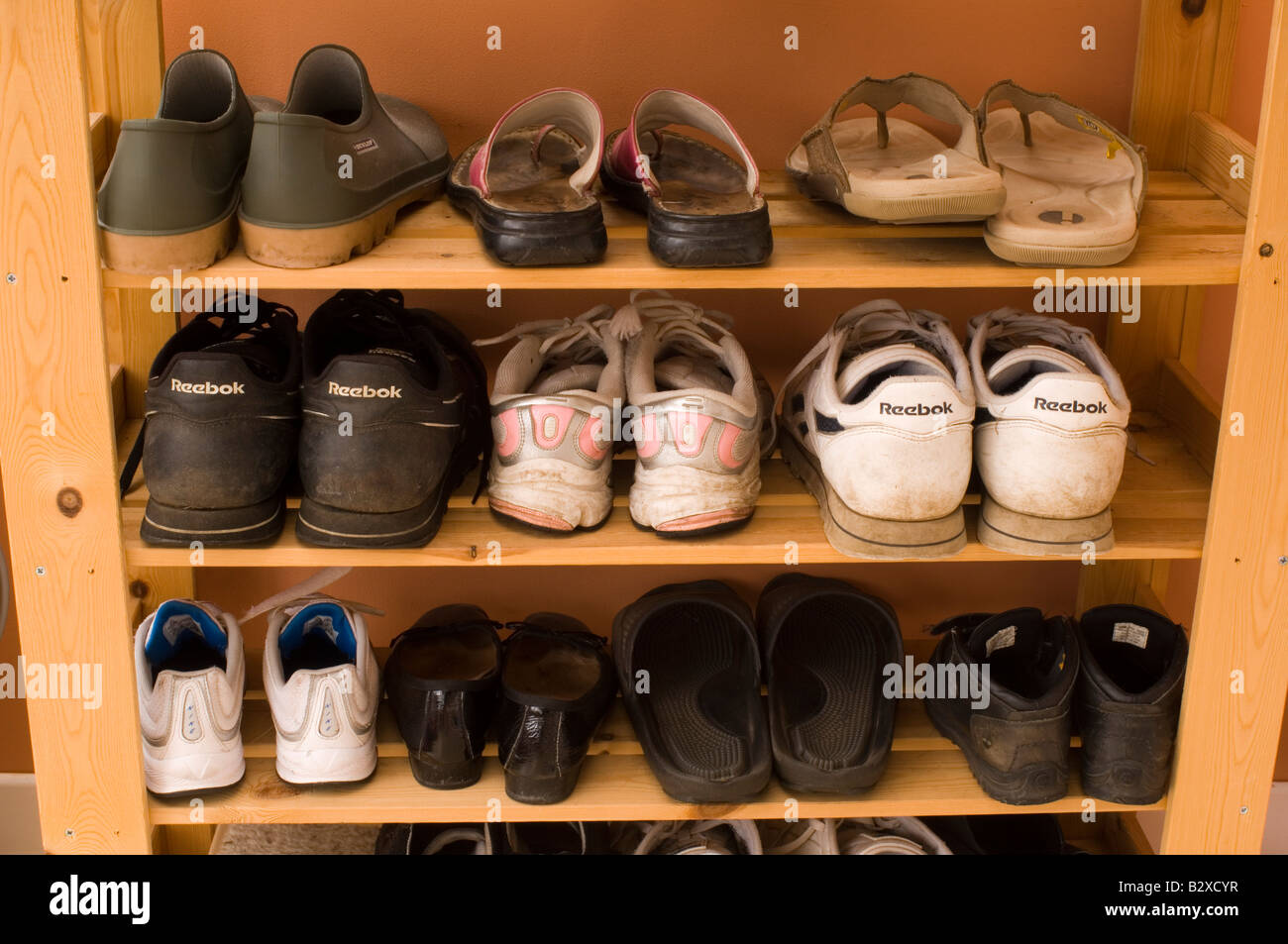 A Shoe rack housing lots of pairs of shoes and trainers Stock Photo Alamy