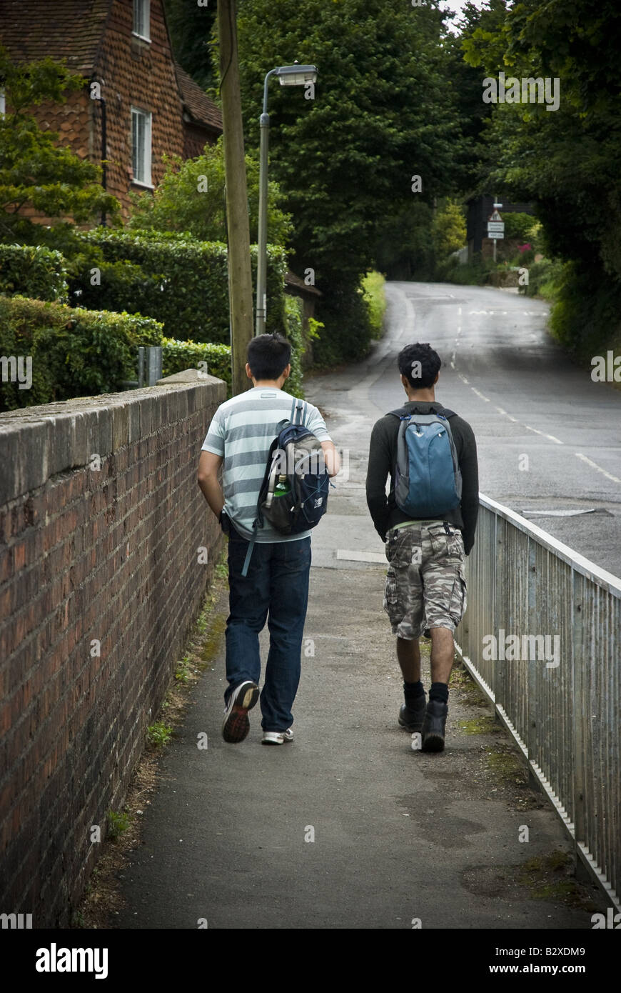 Two hikers walk across a bridge near Haslemere in Surrey County, England, UK. Stock Photo