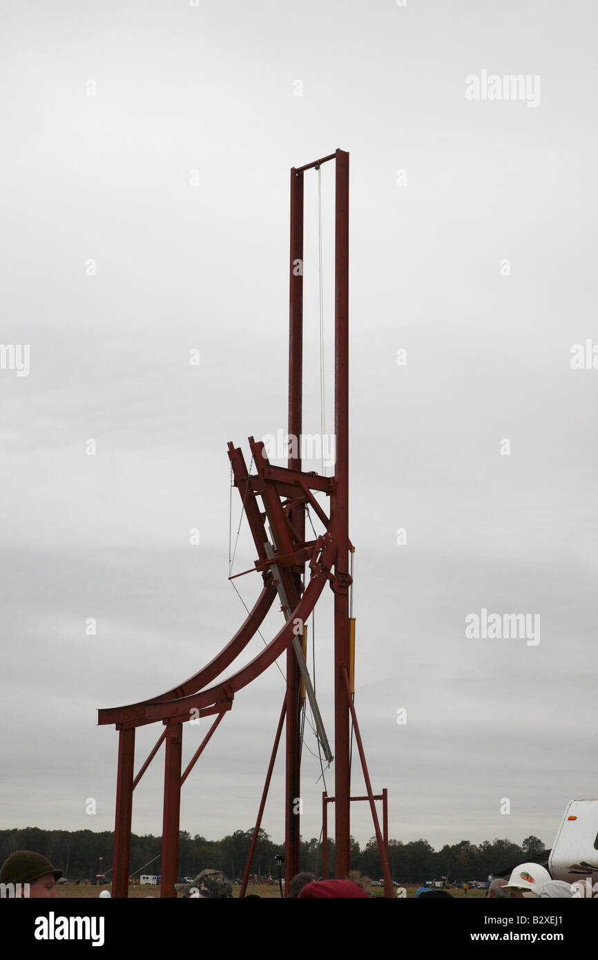 Large arching metal framed trebuchet with arm wound down ready to load and fire. Stock Photo