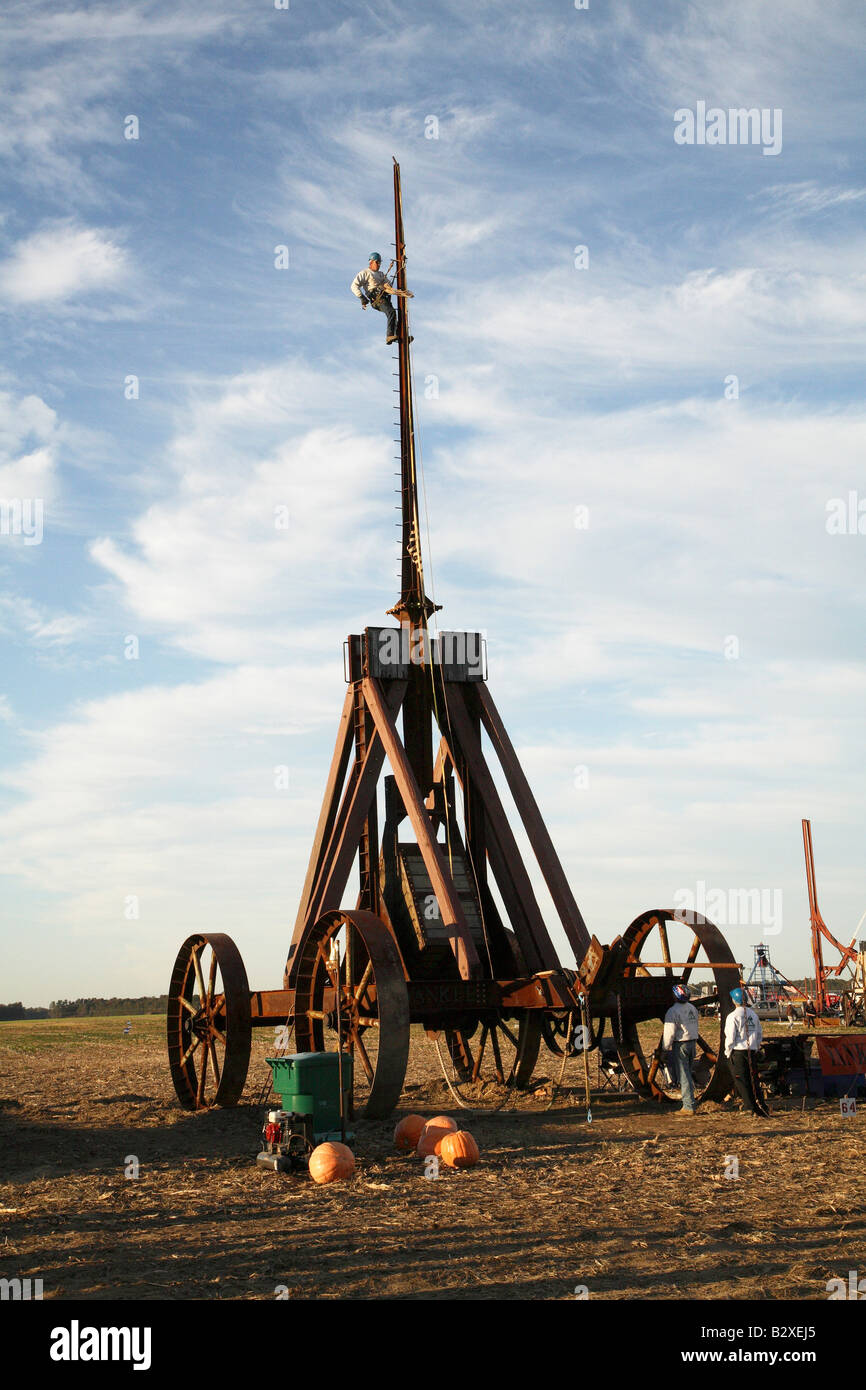 Huge iron wheeled Yankee Siege Trebuchet with person at top of climbing pins on top of arm. Stock Photo