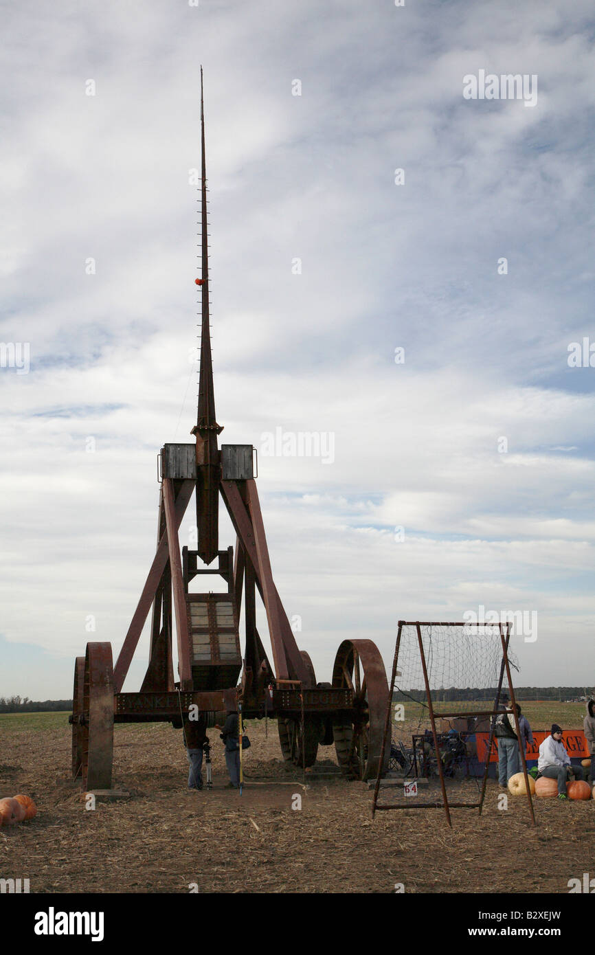 Huge iron wheeled Yankee Siege Trebuchet from behind. Tall skyward pointing arm and a couple of people standing right underneath Stock Photo