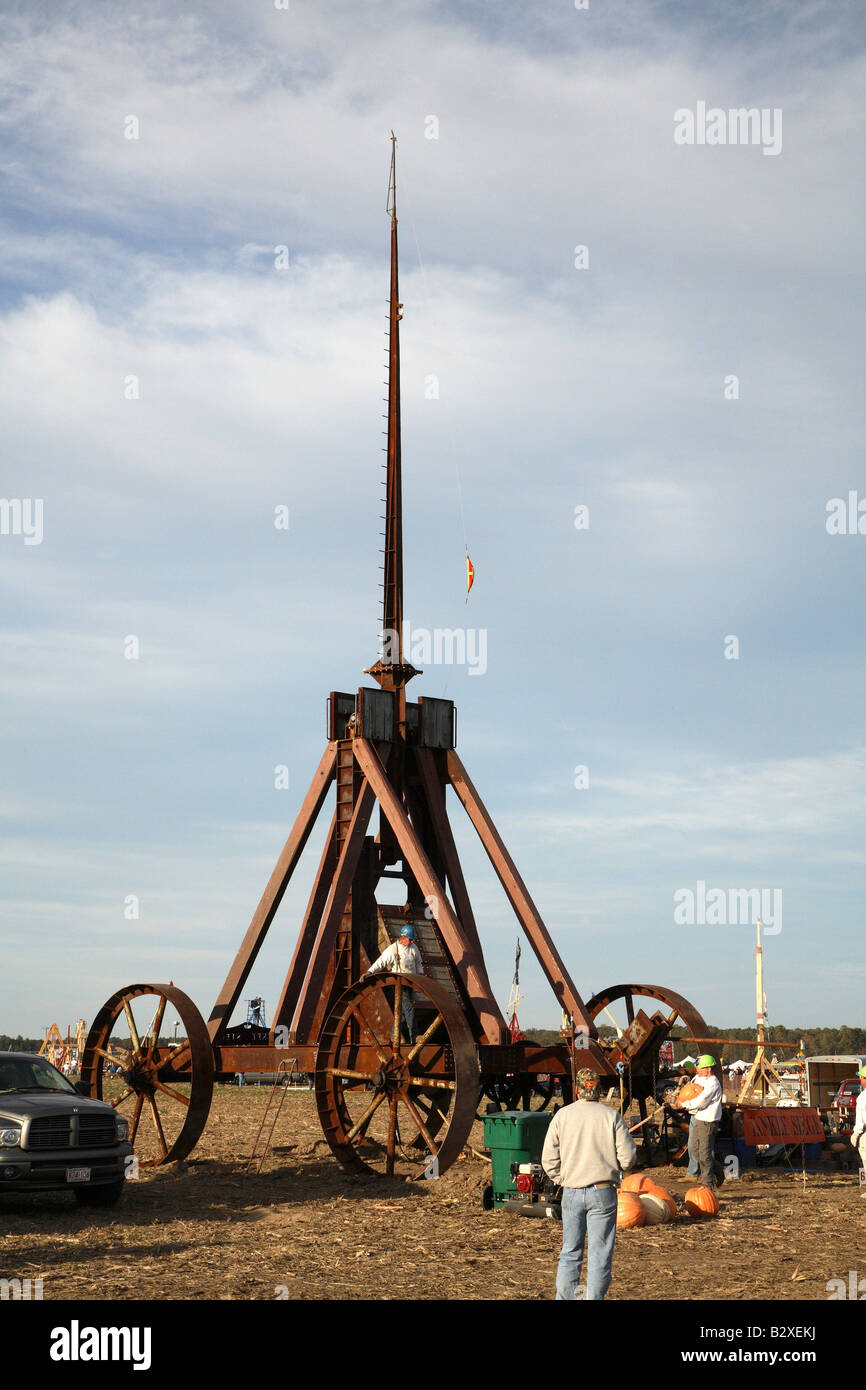 Huge iron wheeled Yankee Siege Trebuchet with person standing on frame holding onto the top of the back wheel. Stock Photo