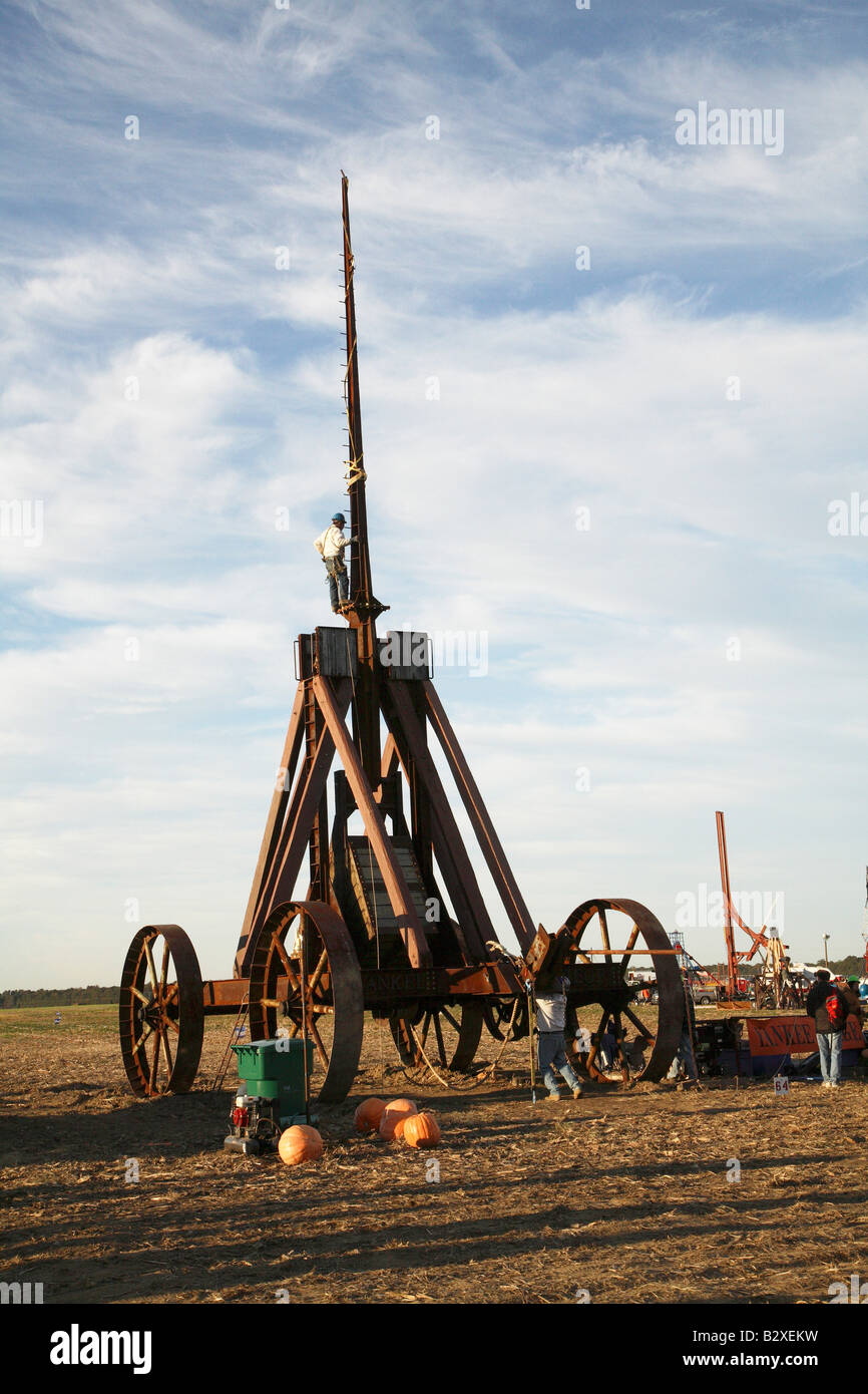 Huge iron wheeled Yankee Siege Trebuchet with person standing on tiny ledge at bottom of tall arm Stock Photo