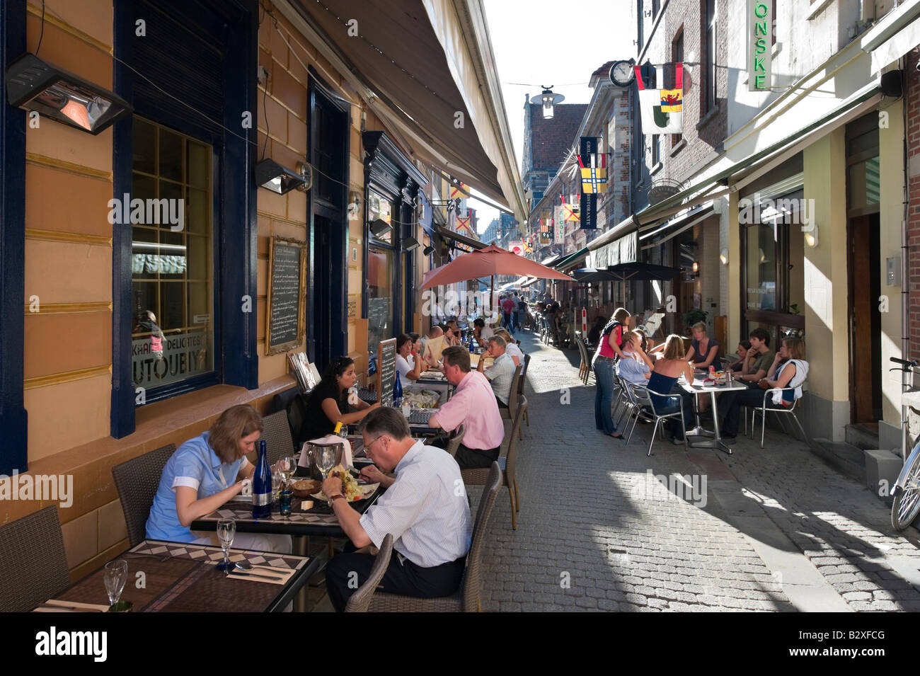 Dinner at sidewalk restaurants in the narrow pedestrianised street of Muntstraat, Leuven, Belgium Stock Photo