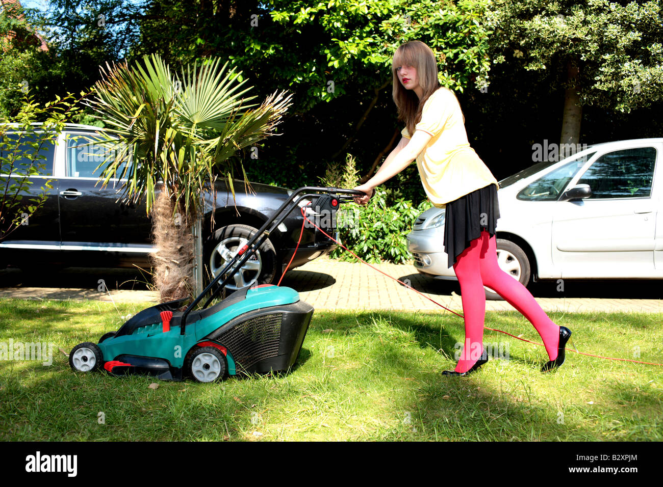 Teenage Girl Mowing the Lawn Model Released Stock Photo