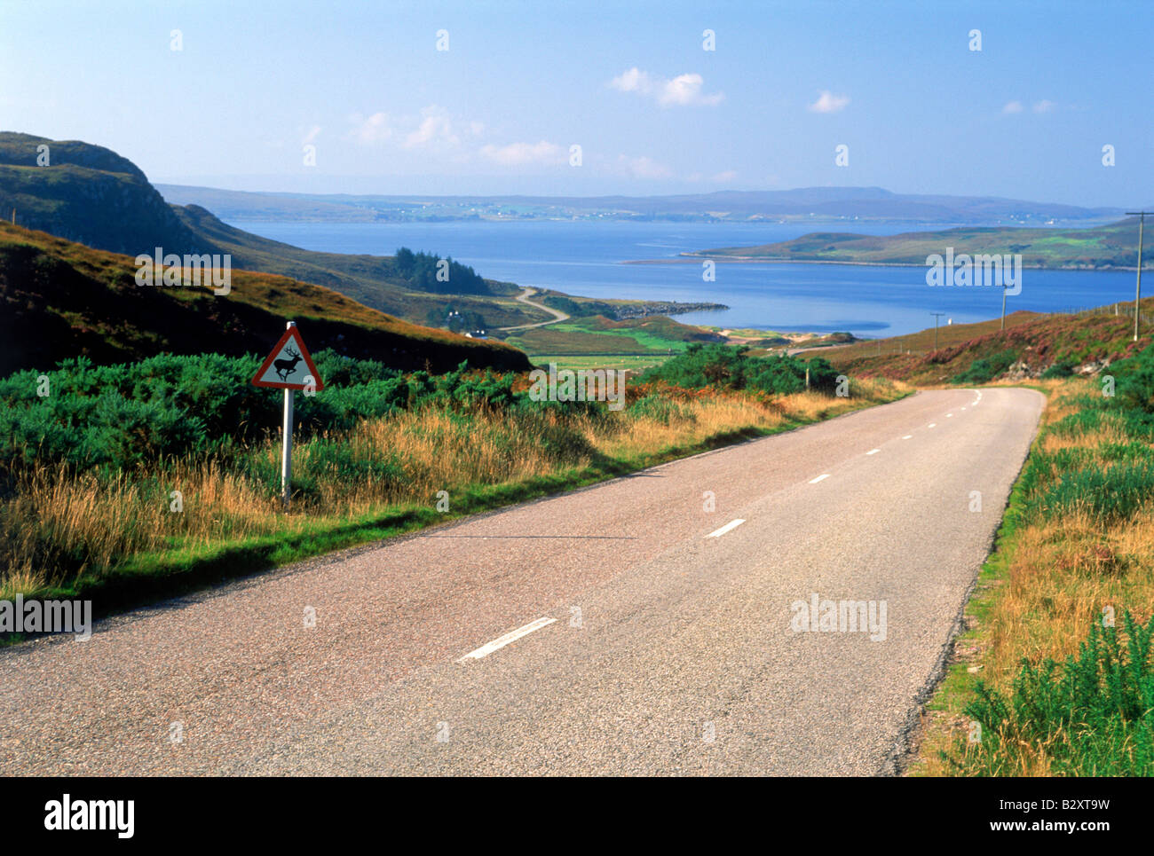 Highway winding along Gruinard Bay and lush hillsides of Scotland Stock Photo