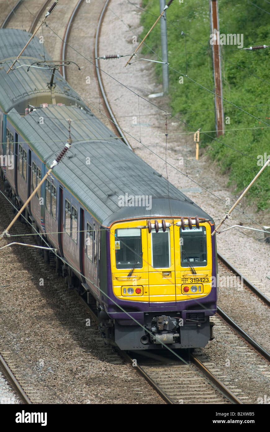 class 319 train in first capital connect livery travelling beneath catenary in the uk Stock Photo
