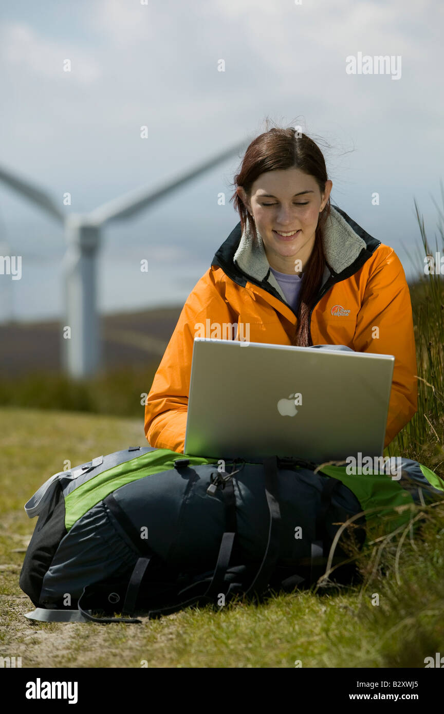 Female with laptop and wind turbine in background Stock Photo