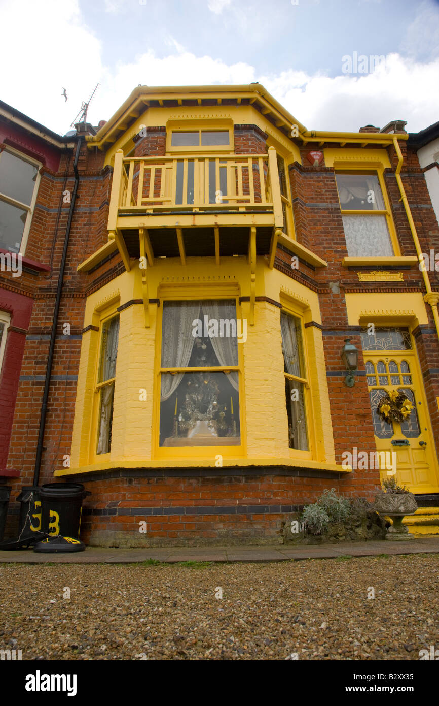 Brick built house painted in bright yellow colour scheme Stock Photo