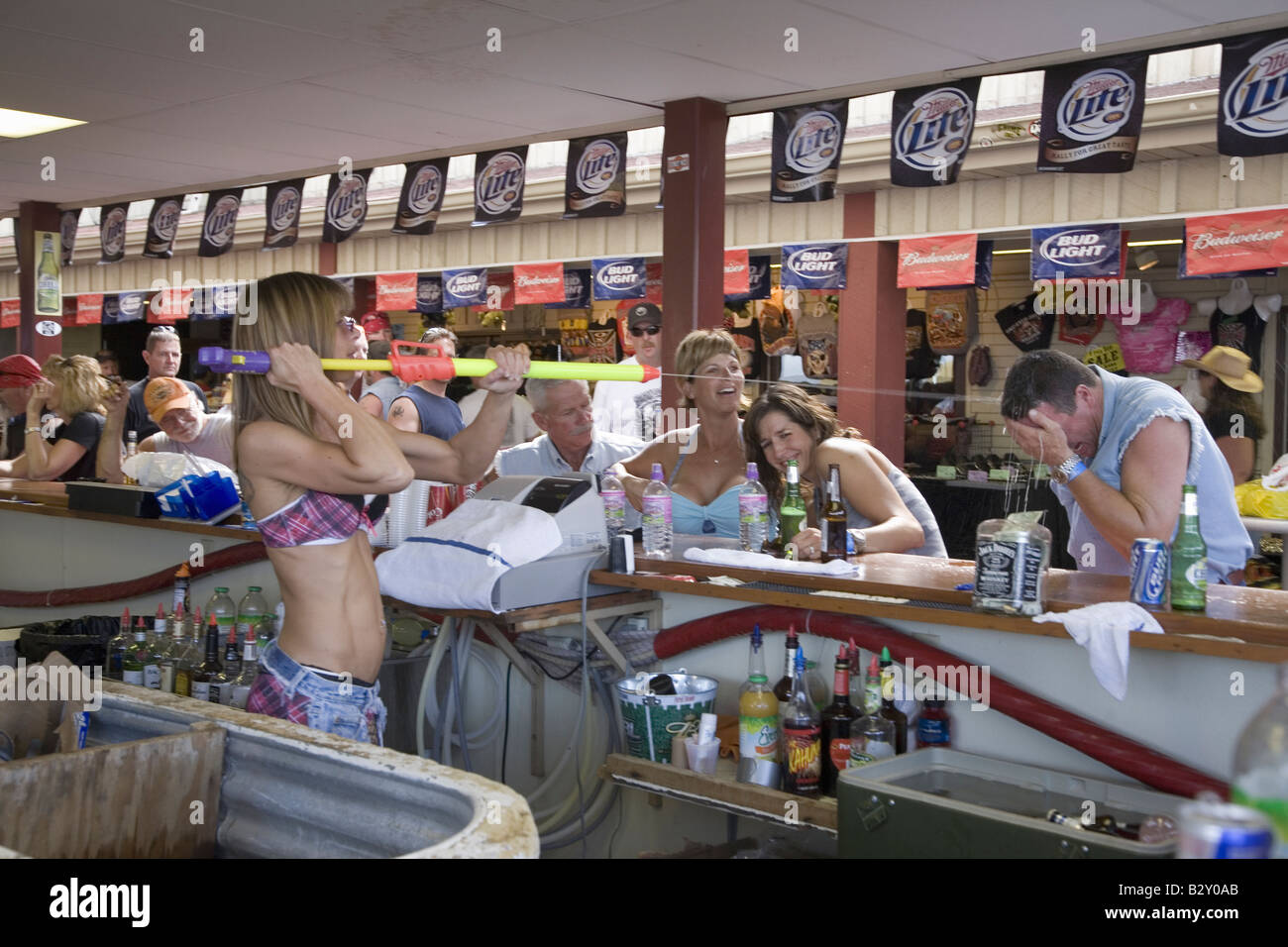 Female bar tender shooting patrons with squirt gun at the 67th Annual Sturgis Motorcycle Rally, SD Stock Photo