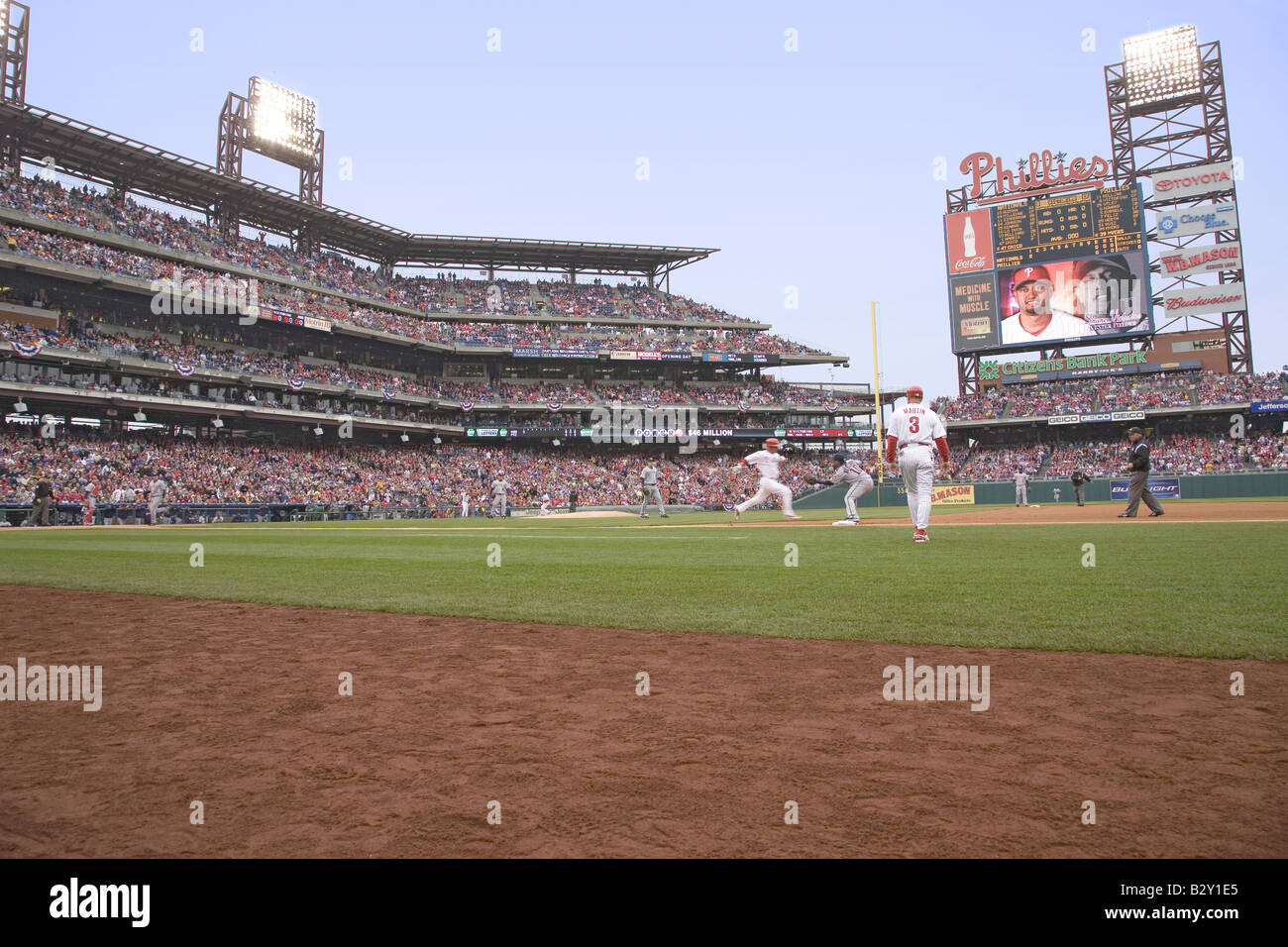 Dugout view of baseball player running to first base during opening