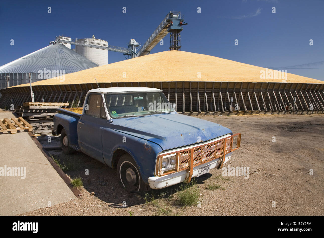 Old blue pickup truck in front of corn storage in North Platte