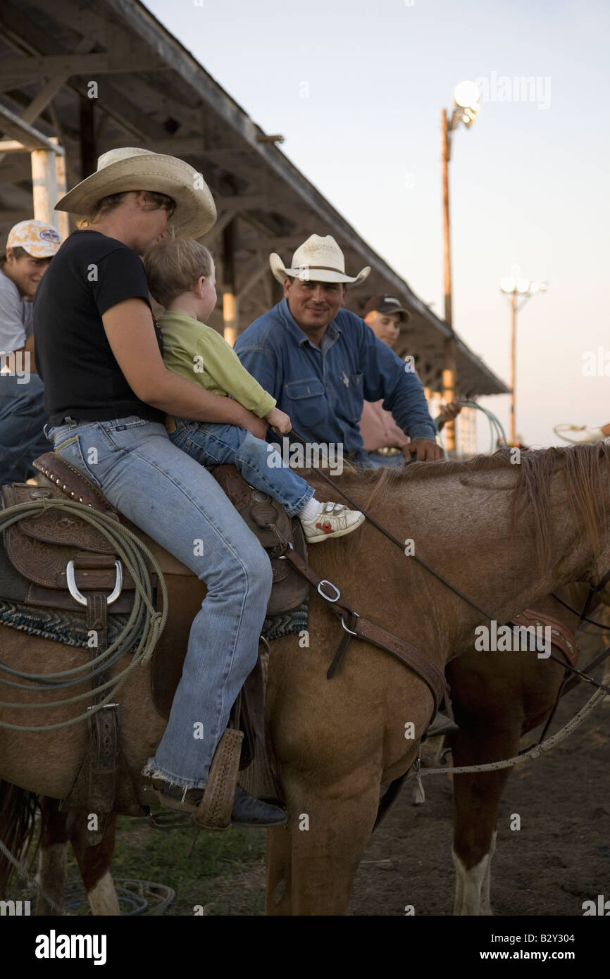 Little boy sitting on horse with cowboy at PRCA Rodeo at Lower Brule