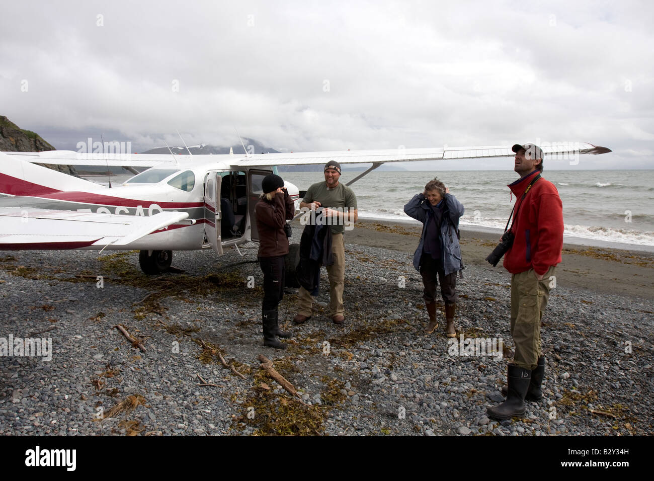 Tourist boarding a small airplane that will fly them back to Homer after a bear watching trip on a beach in Katmai National Park Stock Photo