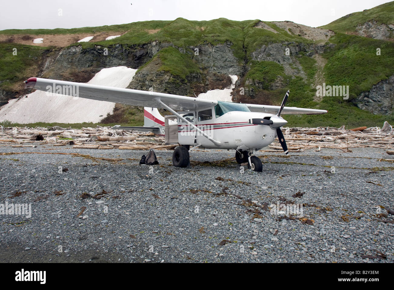 Airplane landed on a beach filled with driftwood at Katmai National Park and Preserve, Alaska Stock Photo