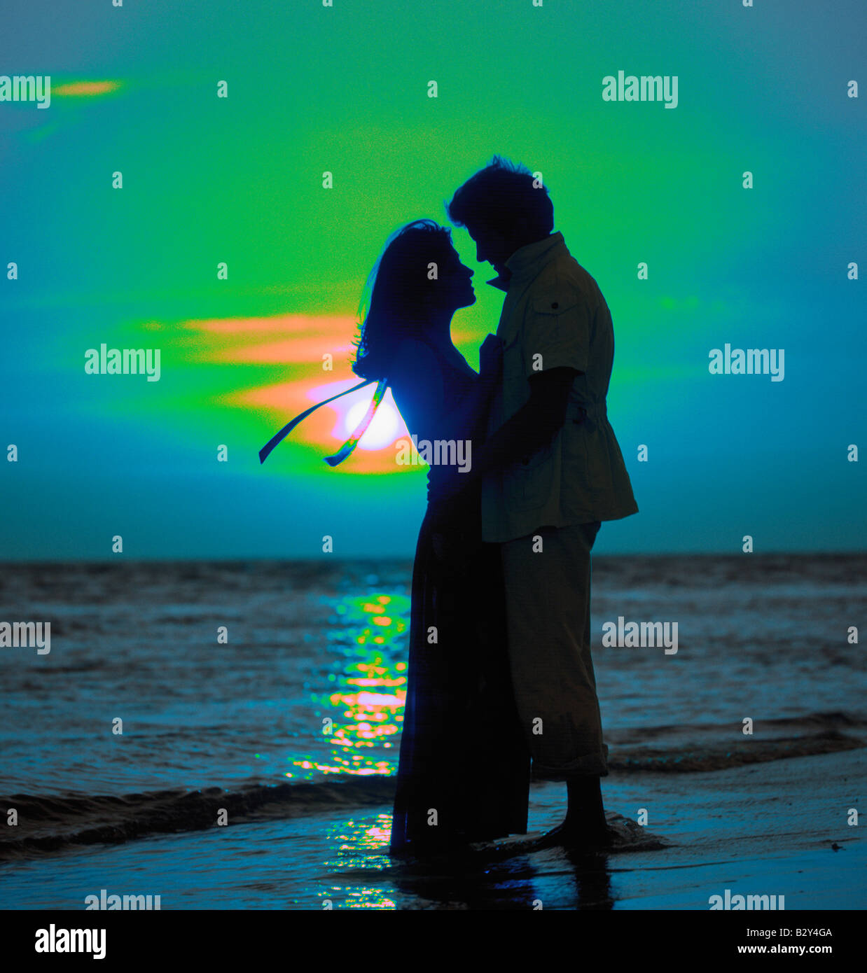 romantic couple embracing on beach at sunset Stock Photo - Alamy