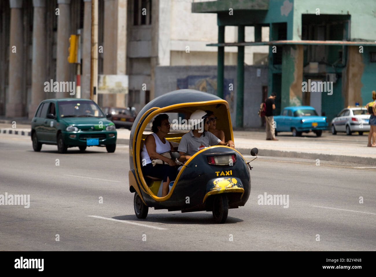 A coco taxi drives along the malecon in Havana, Cuba Stock Photo