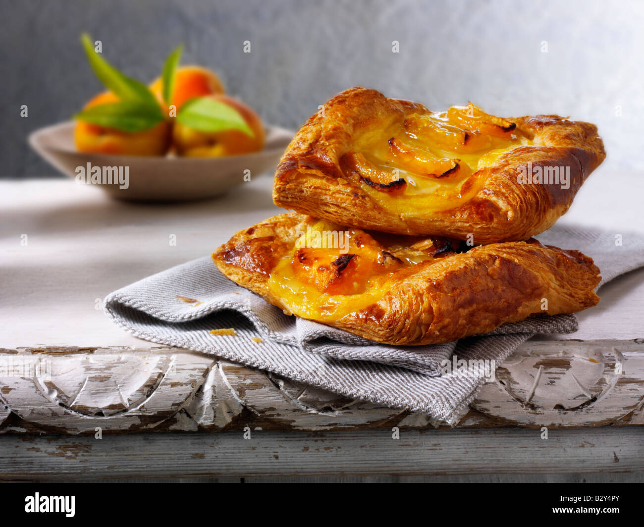 Glazed apricot pastry slice on a napkin on a rustic table Stock Photo