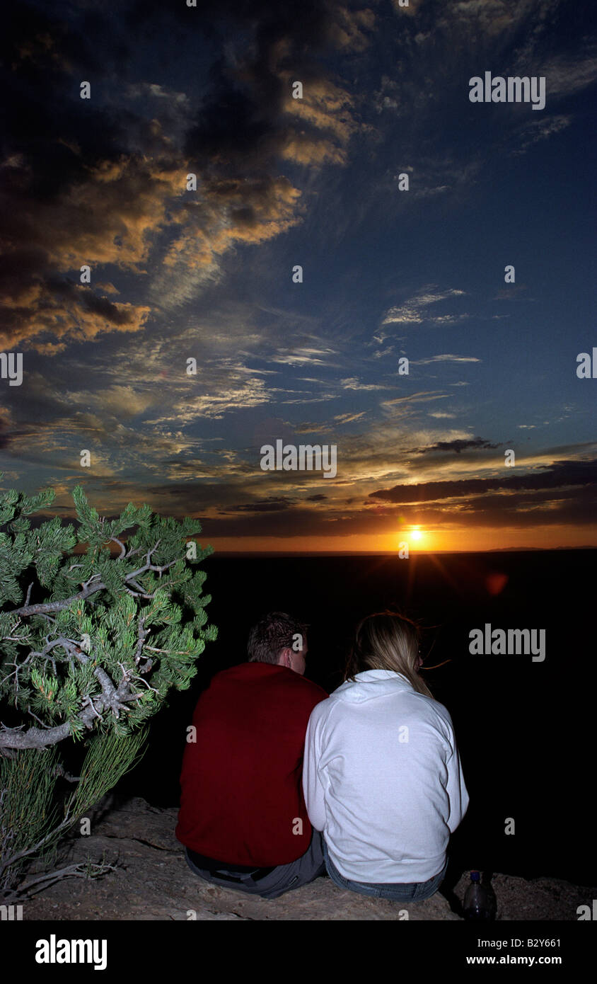 A man and a woman sit together at the edge of the Grand Canyon at ...