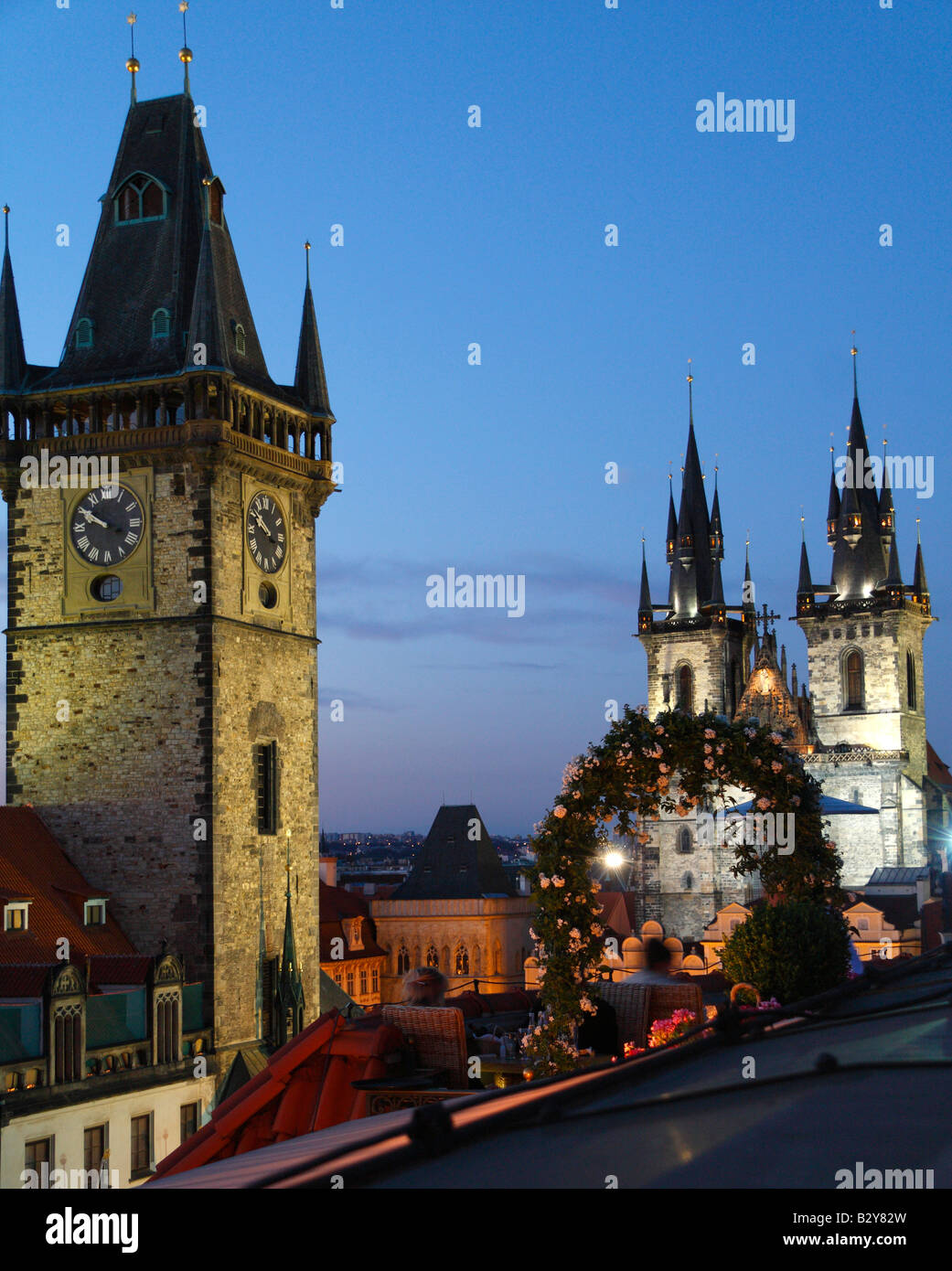 A late evening elevated view of the illuminated towers of the Church of Our Lady before Tyn and the Old Town Hall in Prague Stock Photo