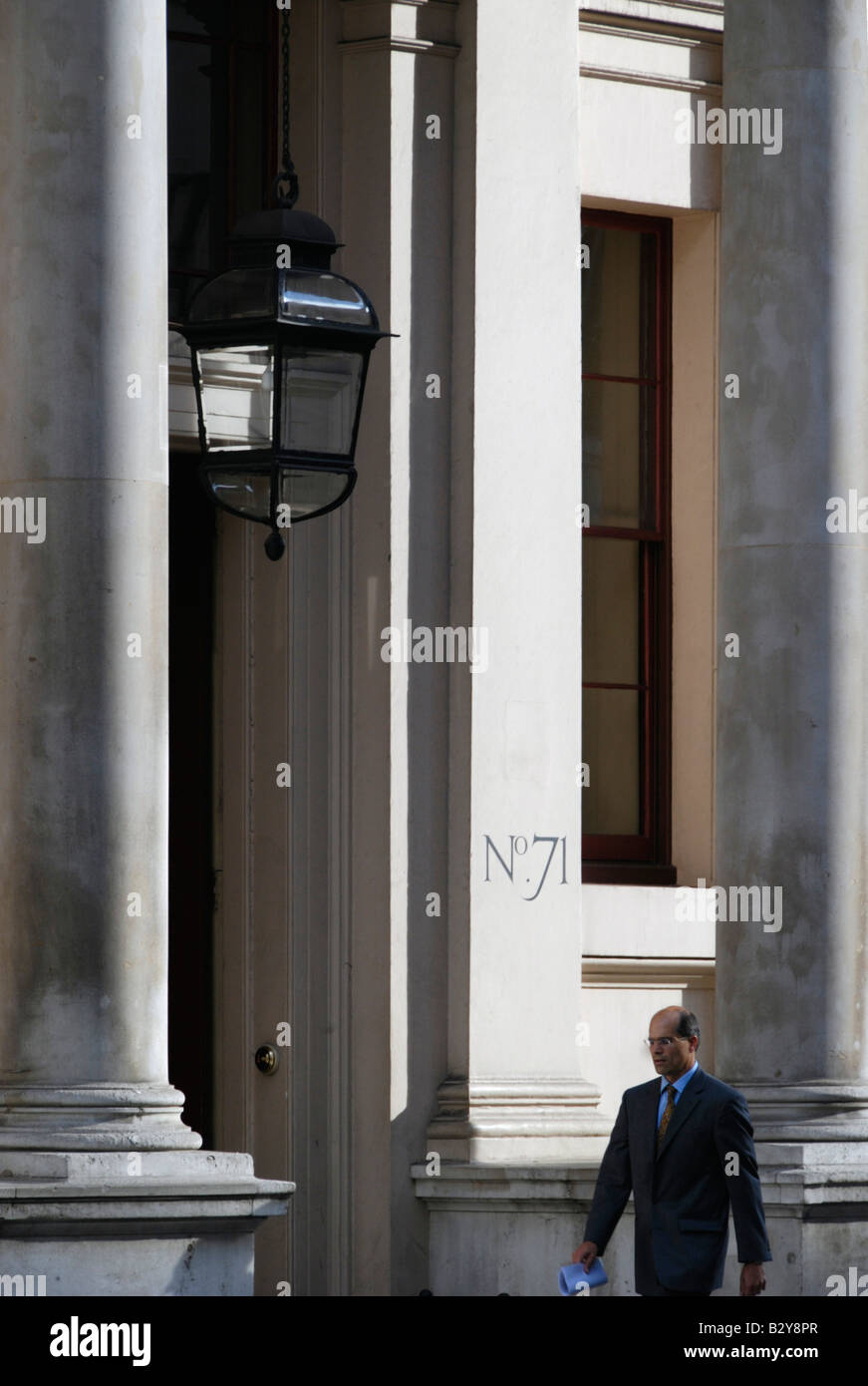 Businessman passing the Oxford and Cambridge club at 71 Pall Mall, London, England Stock Photo