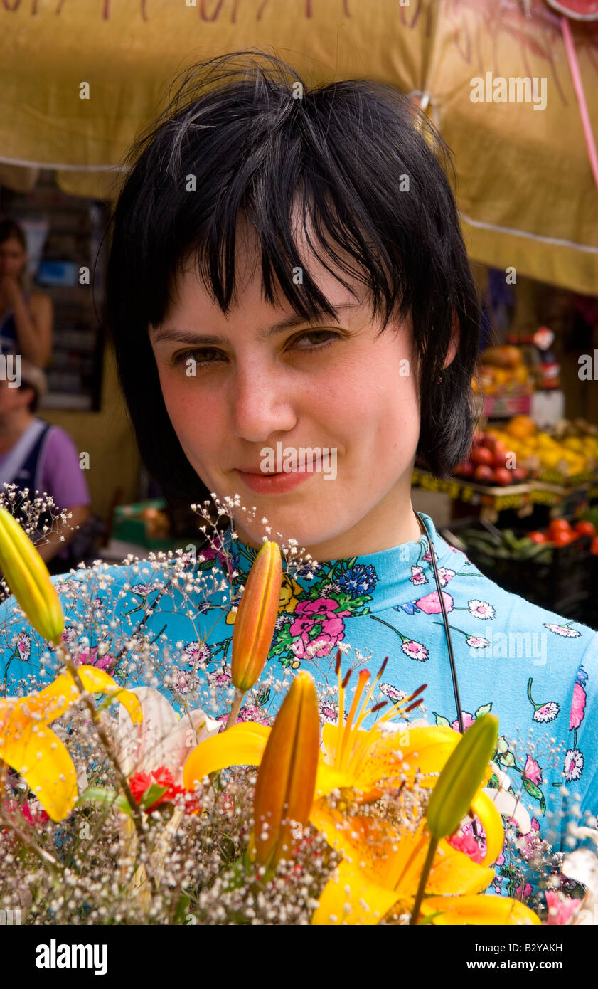 Attractive woman buying flowers at market in old town center city of