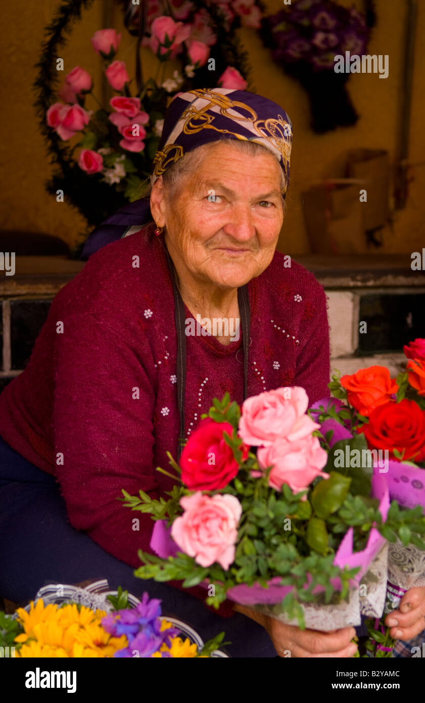 Old lady babushkas selling flowers at market in old town center city of