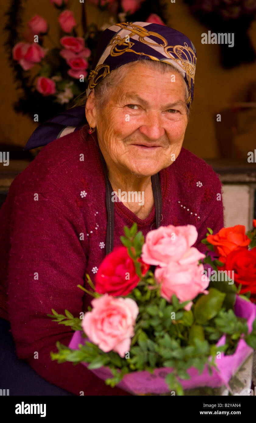 Old lady babushkas selling flowers at market in old town center city of