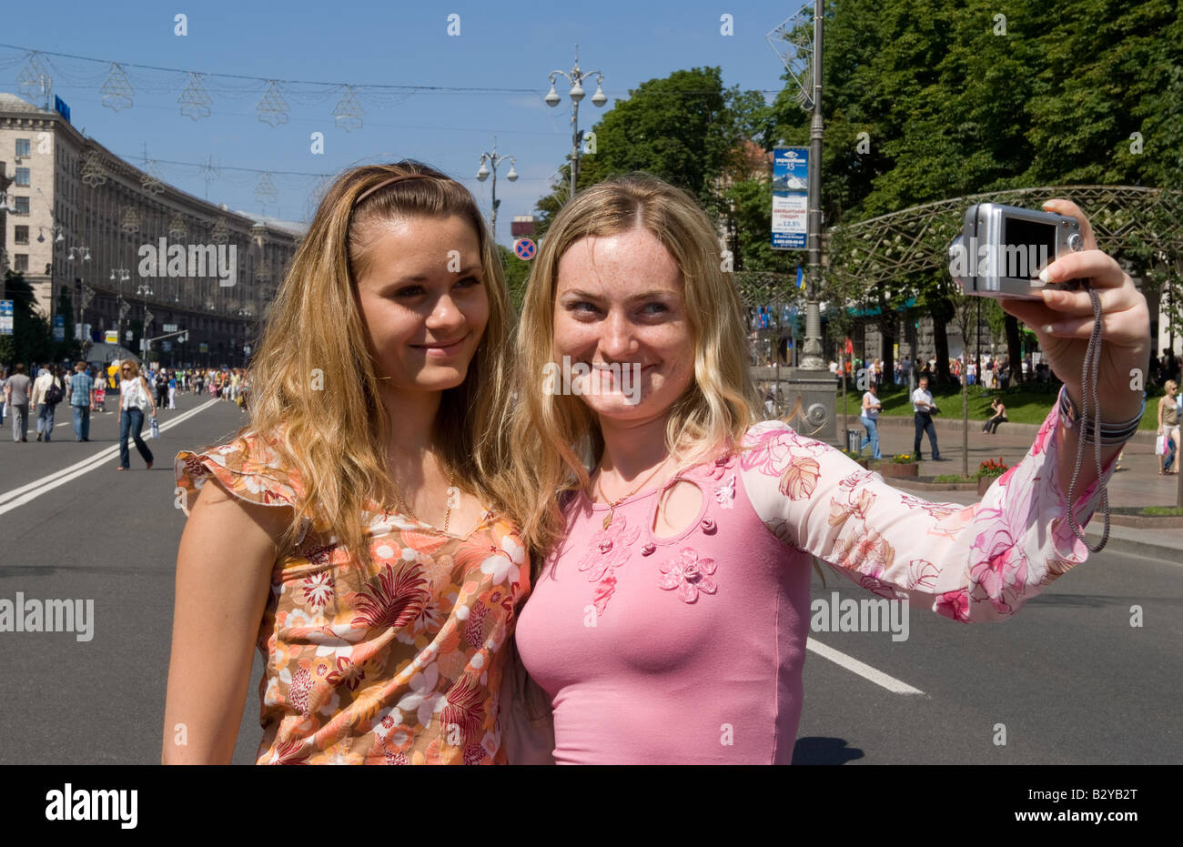 Two teenage girls taking self portrait with camera in street festival of closing the main street Khrechatk Street Kiev Ukraine Stock Photo