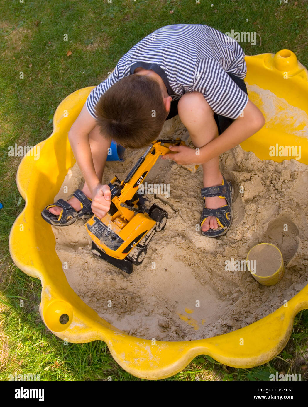 Boy playing with toy digger in sand pit Stock Photo Alamy