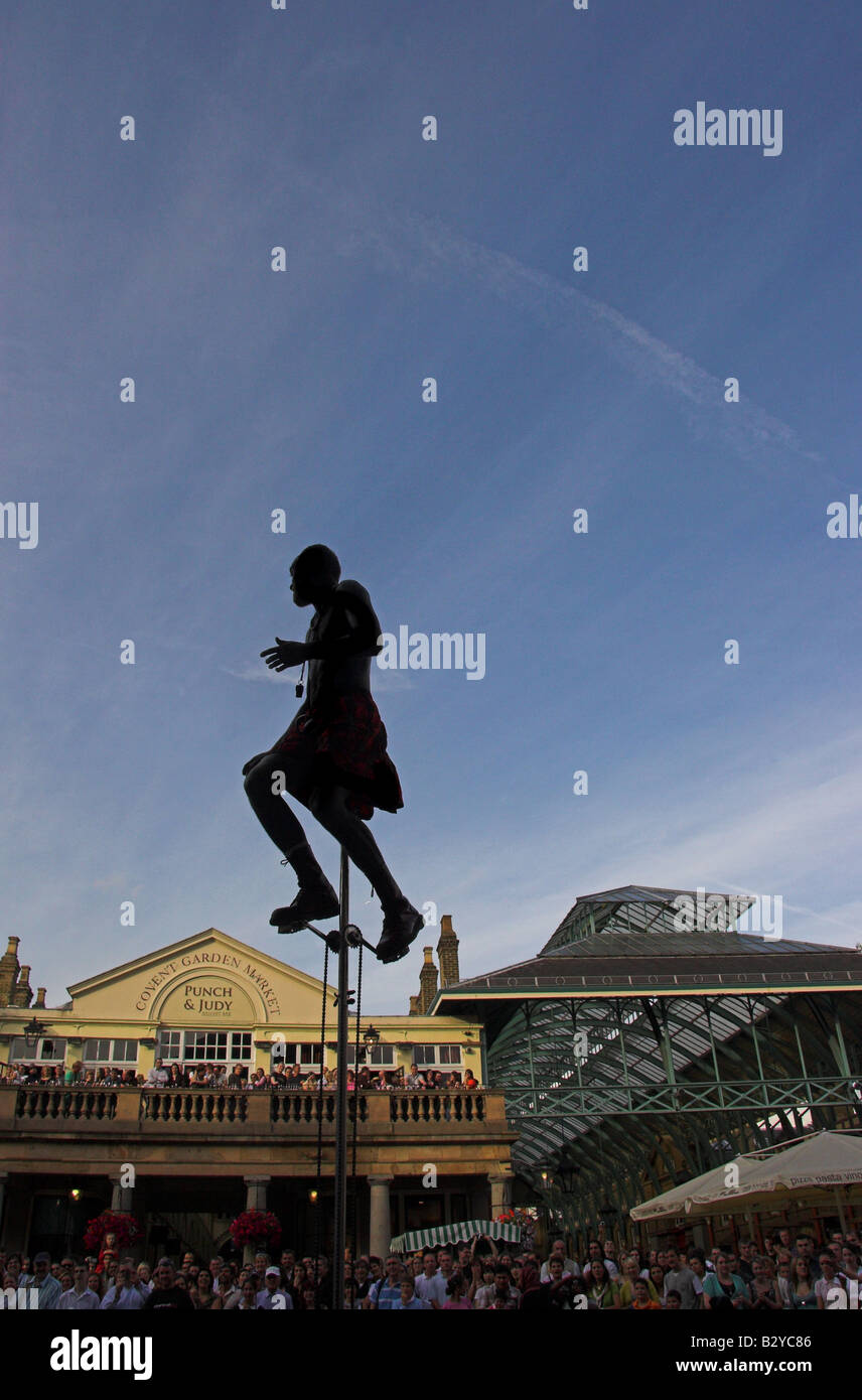 Street performer on a tall unicycle in Covent Garden, London Stock