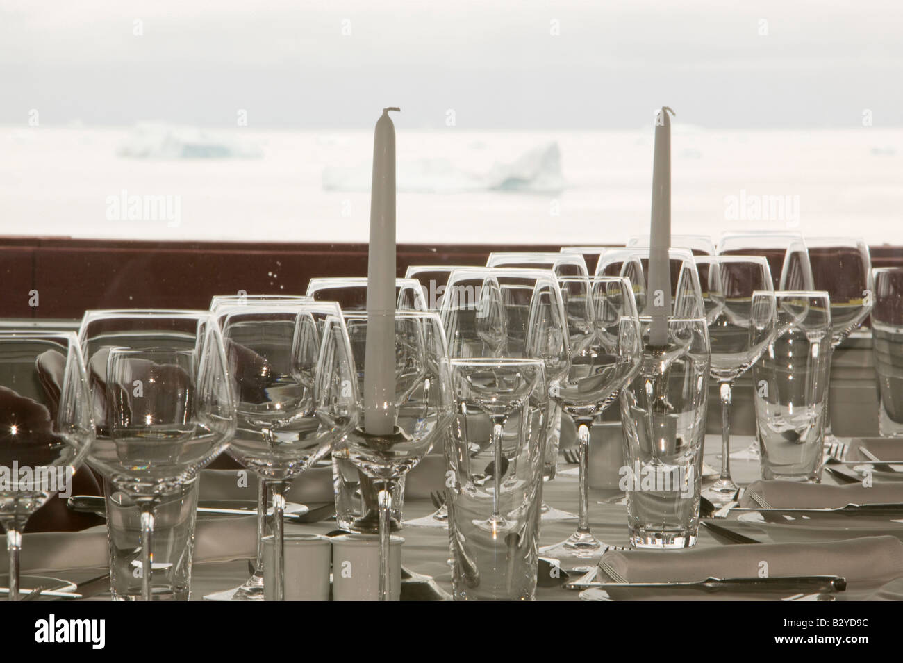 A place setting in the restaurant of the Arctic Hotel in Ilulissat on Greenland with icebergs in the background Stock Photo