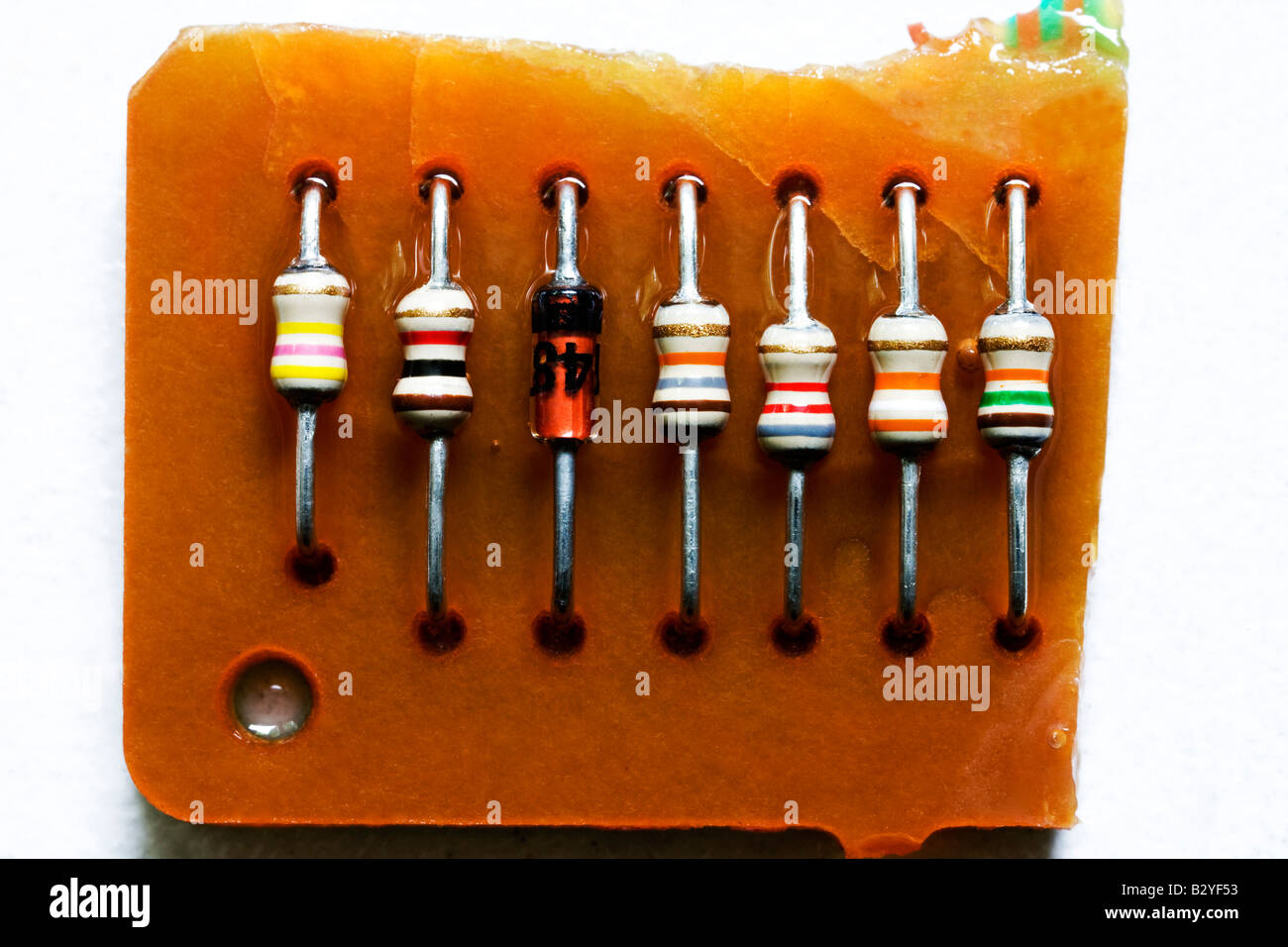 Six resistors of different sizes on a circuit board Resistors are