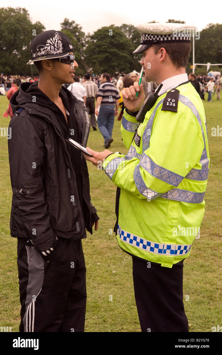 Metropolitan Police Officer questioning Asian youth at London Mela, 10th August 2008, Gunnersbury Park, London, W3. Stock Photo