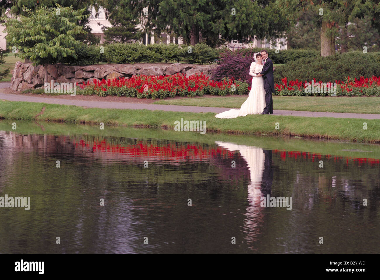 Bride and Groom by lake and Florals Stock Photo
