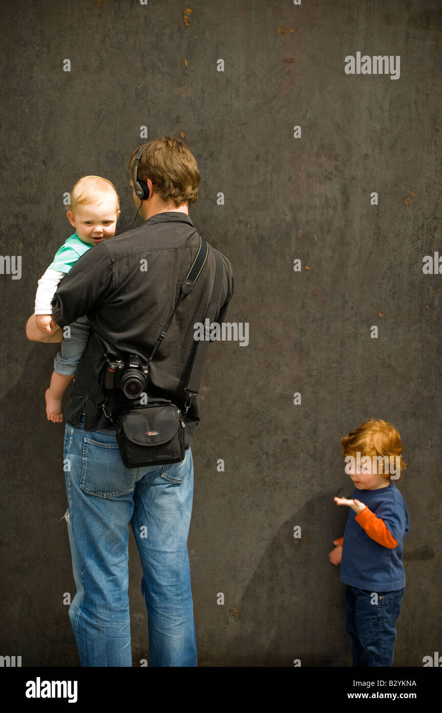 Father and his two children looking at the exhibition 'Promenade' by American sculptor Richard Serra. Stock Photo