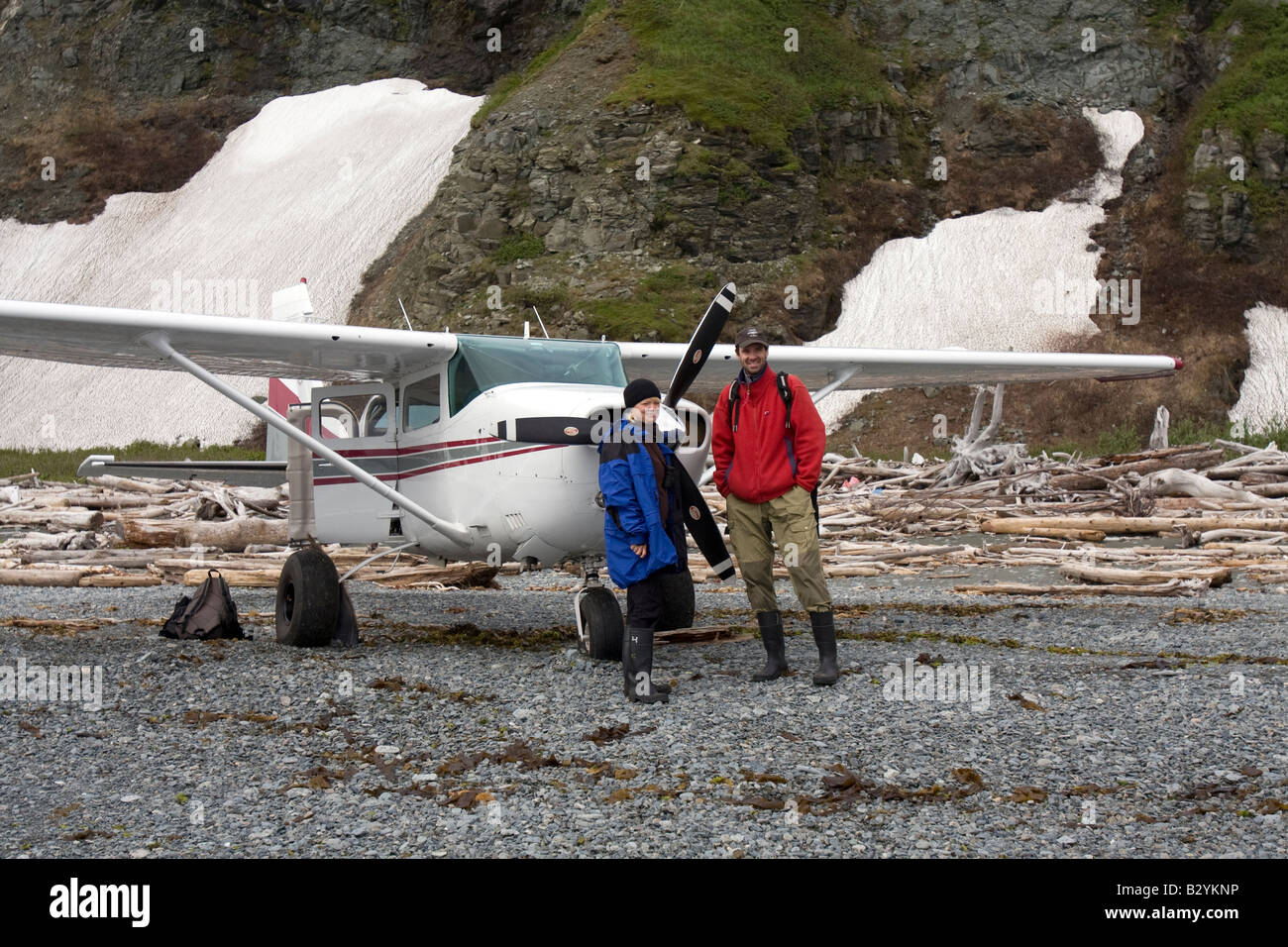 Tourists standing in front of an air plane (Cessna 2007) on the beach of the Katmai National Park and Preserve, Alaska, USA Stock Photo