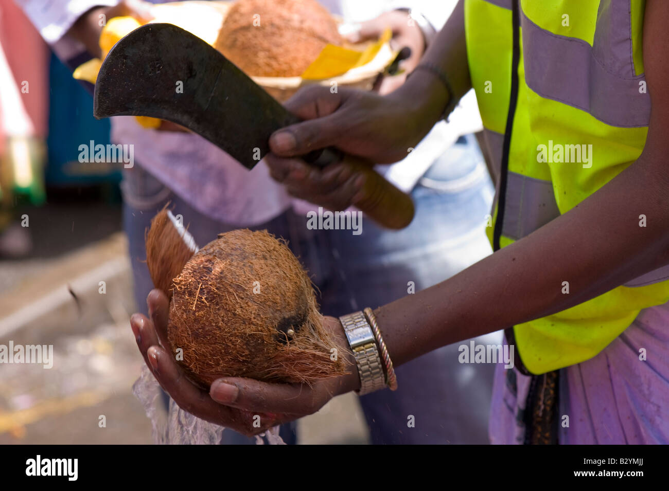 Man opening coconut during religious festivities at Shri Kanaga Amman Temple Ealing W5 London