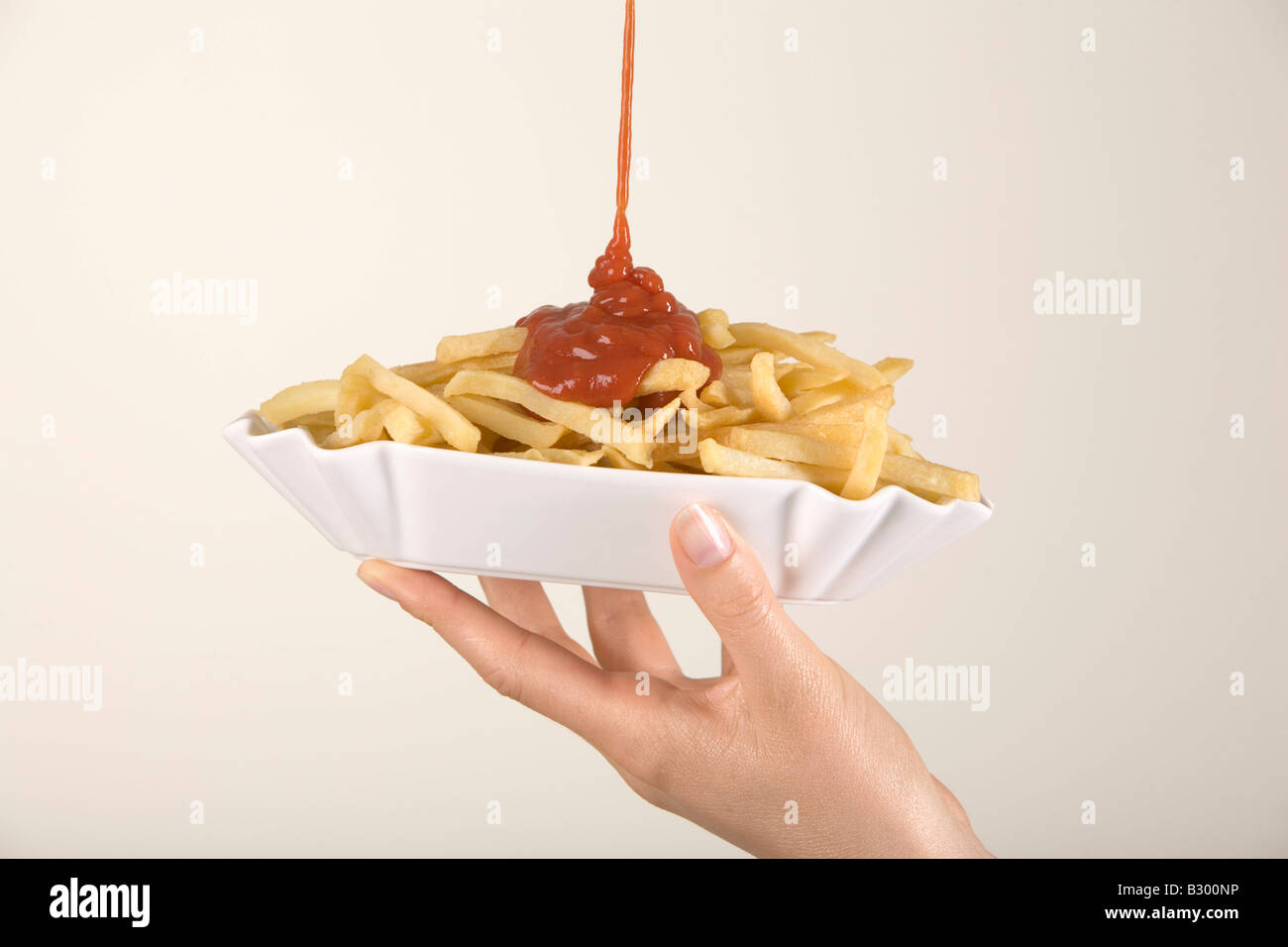 Woman Pouring Ketchup on French Fries Stock Photo Alamy